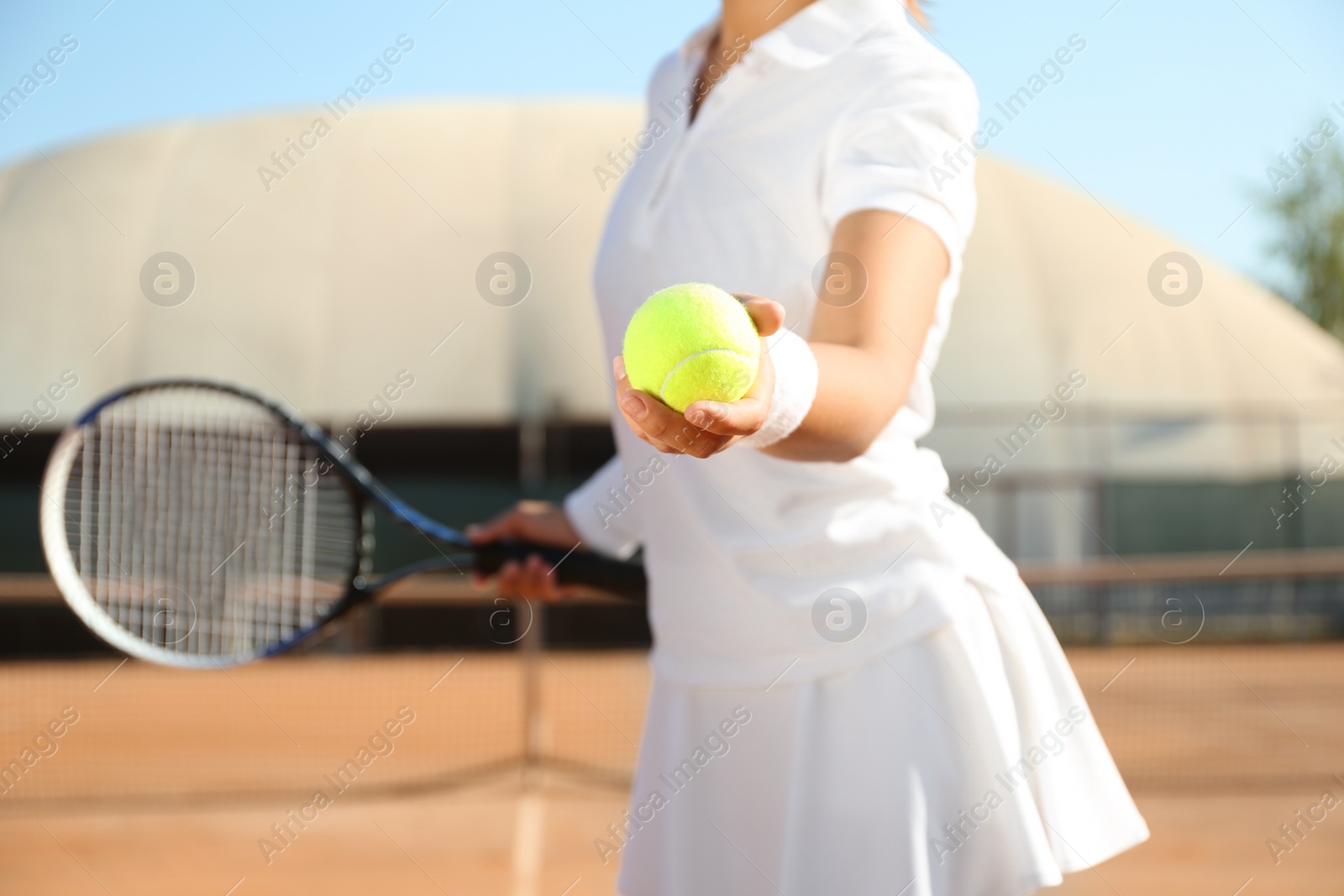 Photo of Sportswoman preparing to serve tennis ball at court, closeup