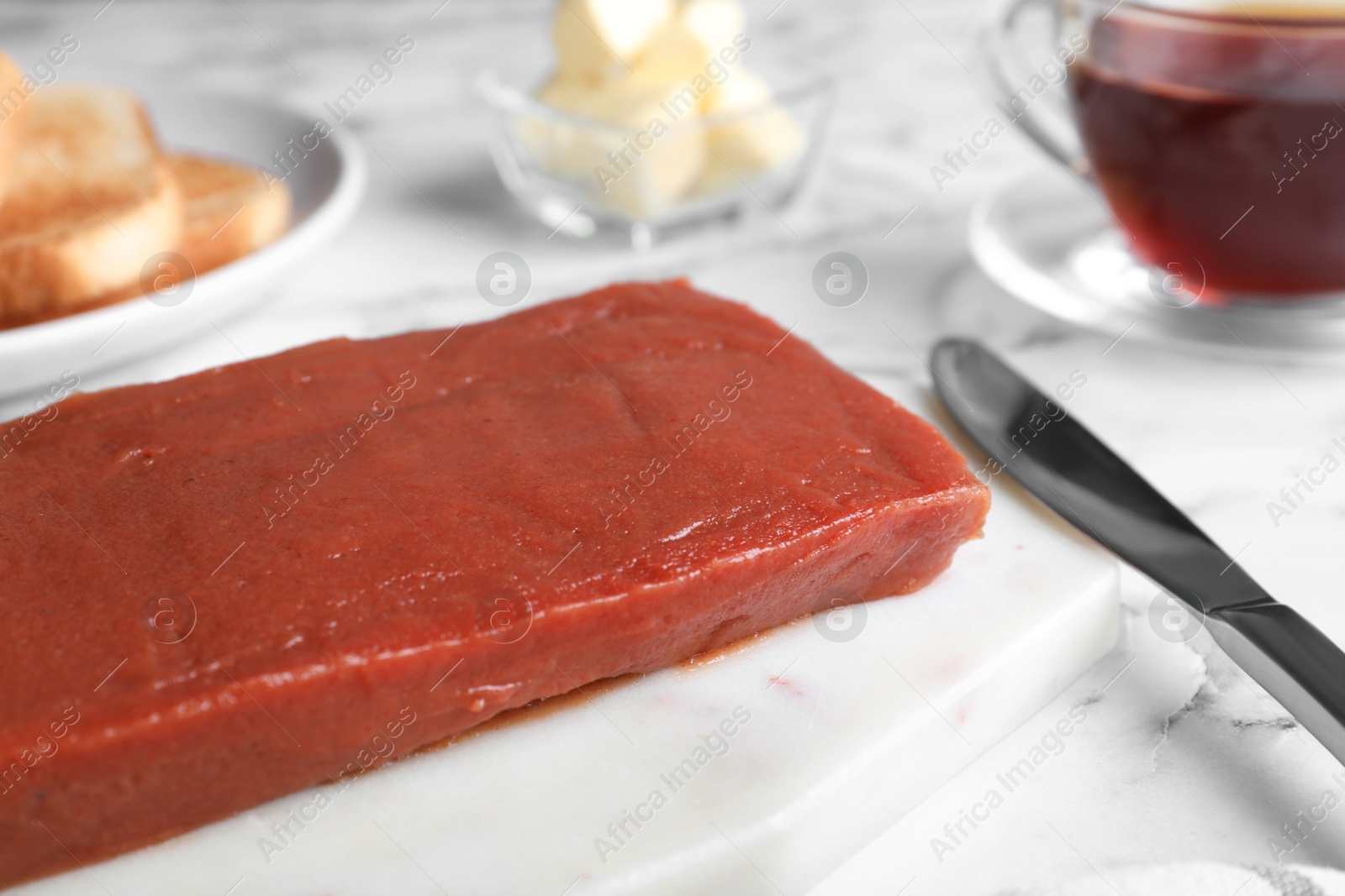 Photo of Quince paste for breakfast on white table, closeup