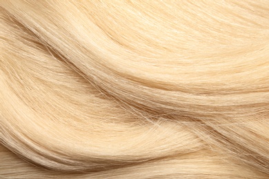 Texture of healthy blond hair as background, closeup