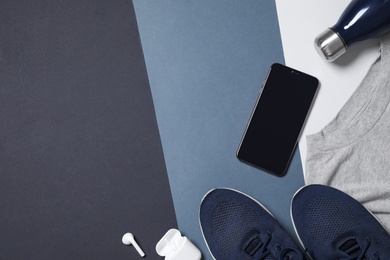 Photo of Flat lay composition with smartphone and sneakers on color background. Space for text