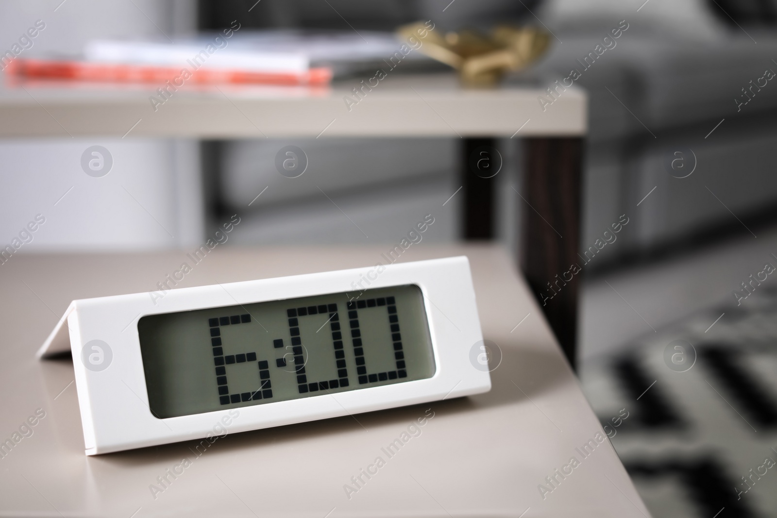 Photo of Digital alarm clock on table in living room. Time of day