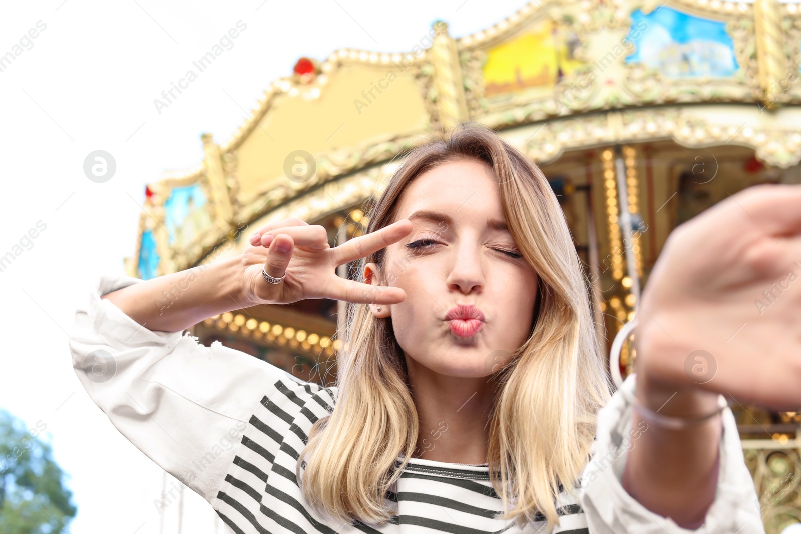 Photo of Attractive woman taking selfie in amusement park