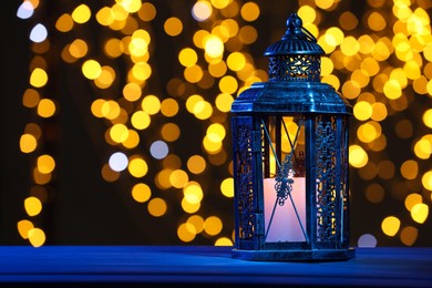 Photo of Traditional Arabic lantern on table against blurred lights at night. Space for text