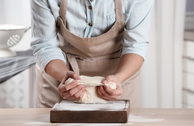 Female baker preparing bread dough at table, closeup