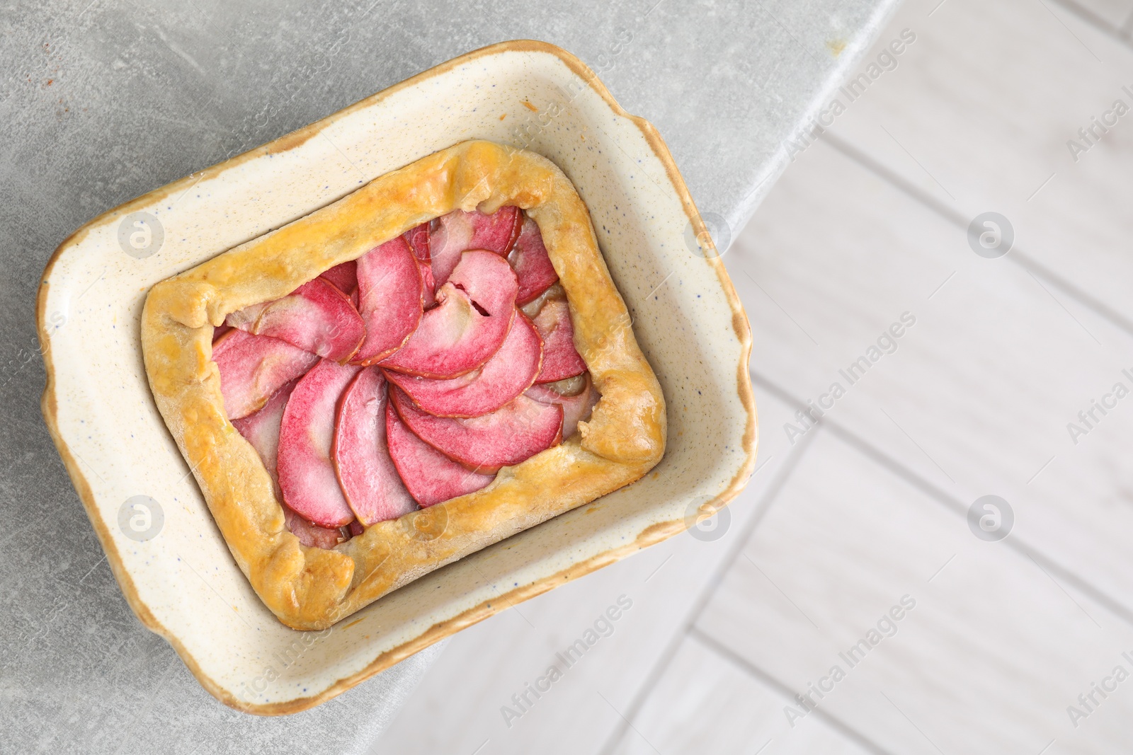 Photo of Tasty galette with apples on light grey table, top view. Space for text