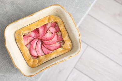 Tasty galette with apples on light grey table, top view. Space for text