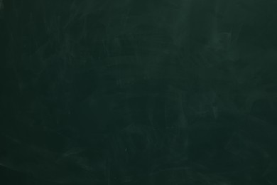 Photo of Chalk rubbed out on green chalkboard as background, closeup. Space for text