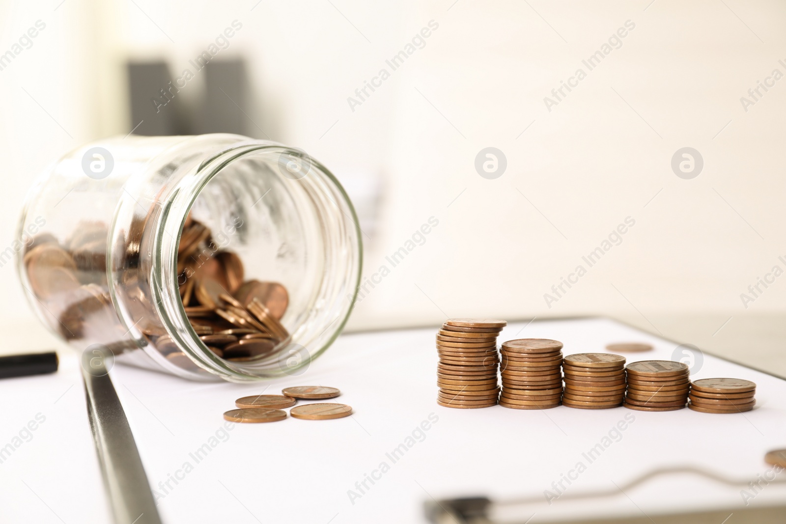 Photo of Stacks of coins on table against blurred background