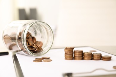 Photo of Stacks of coins on table against blurred background