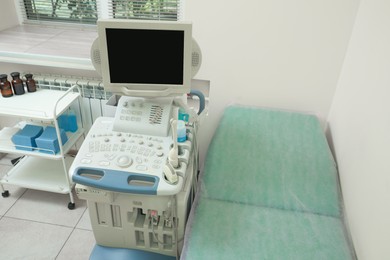 Photo of Ultrasound machine, medical trolley and examination table in hospital, above view