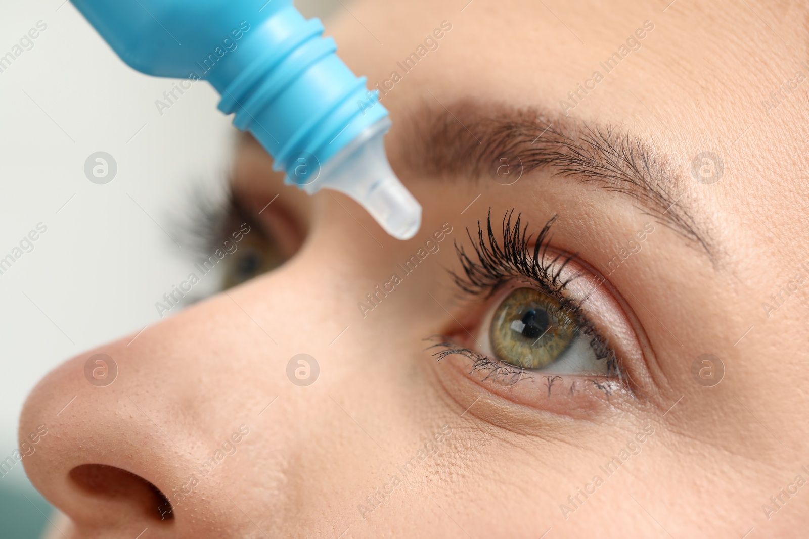 Photo of Woman applying medical eye drops, macro view