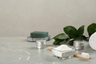 Photo of Composition with tooth powder and green leaves on light grey marble table, space for text