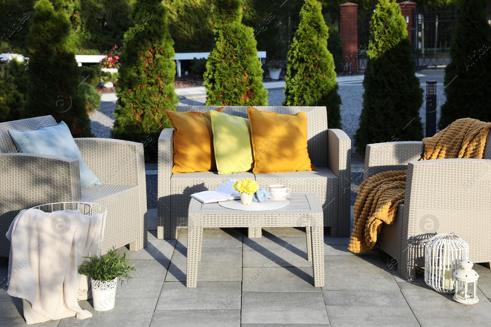 Photo of Beautiful rattan garden furniture, soft pillows and different decor elements in backyard