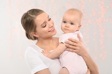 Portrait of happy mother with her baby against blurred lights