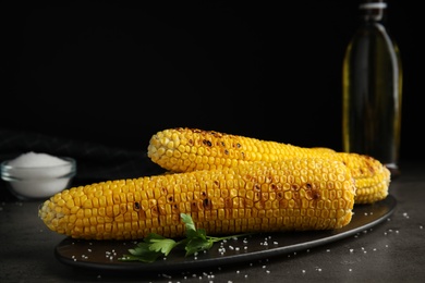 Fresh grilled corn cobs on grey table