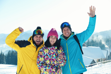 Photo of Happy friends on snowy hill in mountains. Winter vacation