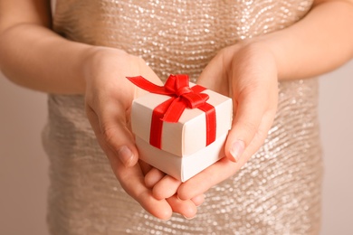 Woman holding beautiful gift box, closeup