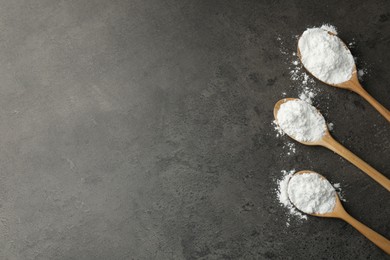 Photo of Baking powder in spoons on grey textured table, flat lay. Space for text