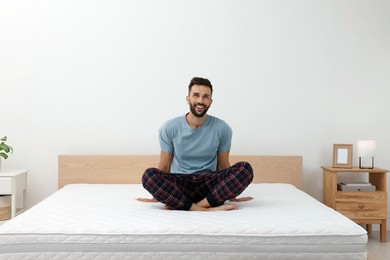 Photo of Happy man on bed with comfortable mattress at home