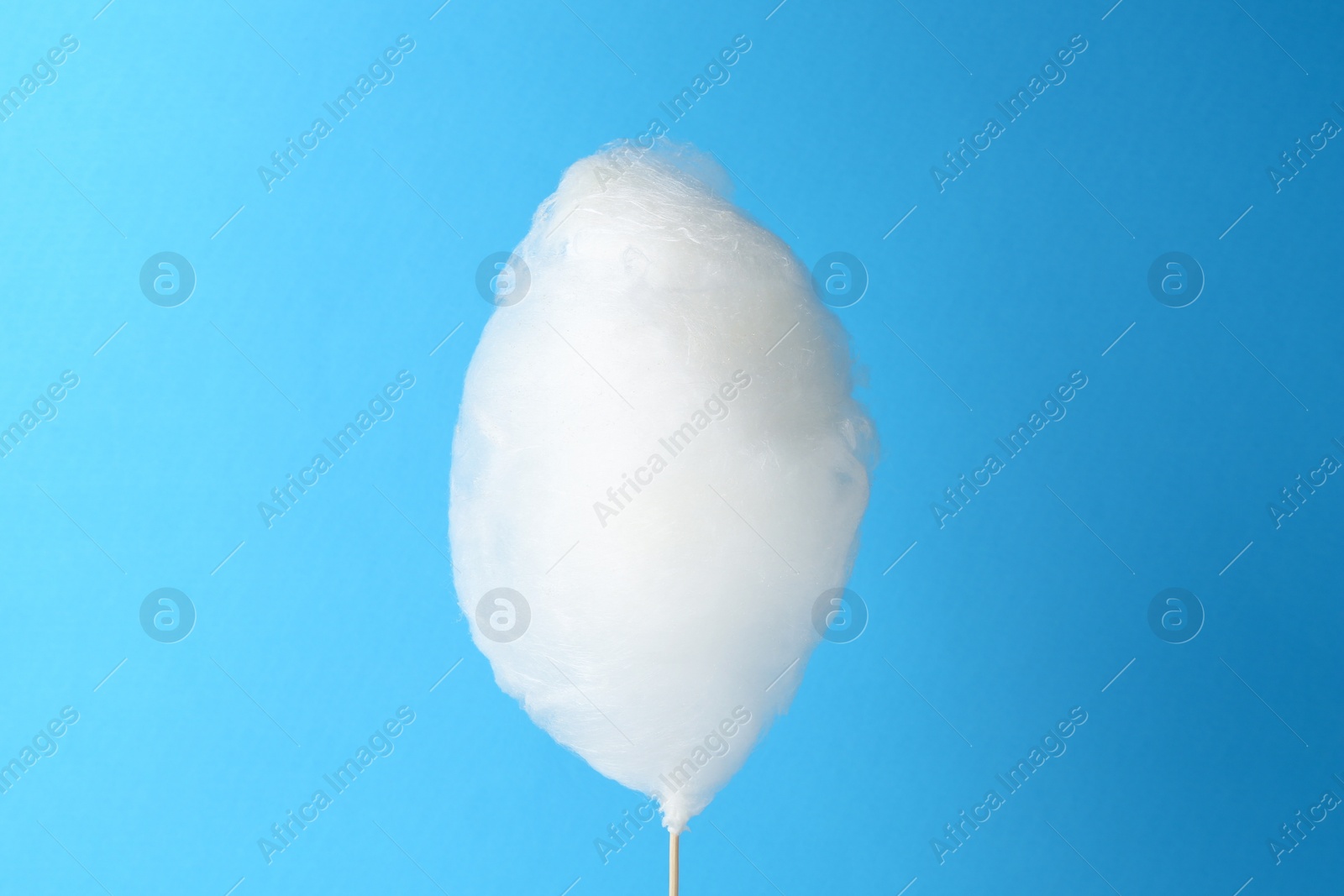 Photo of One sweet cotton candy on light blue background
