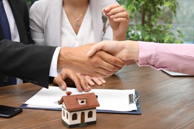 Photo of Man shaking hands with real estate agent on meeting over table