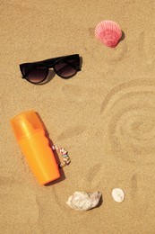 Flat lay composition with sunscreen on sand, space for text. Sun protection care