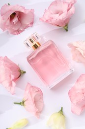 Photo of Luxury perfume and floral decor on white background, flat lay