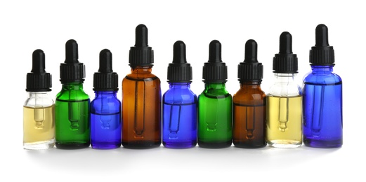 Different little bottles with essential oils on white background