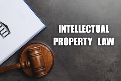 Image of Text Intellectual Property Law, wooden judge's gavel and book on grey background, flat lay