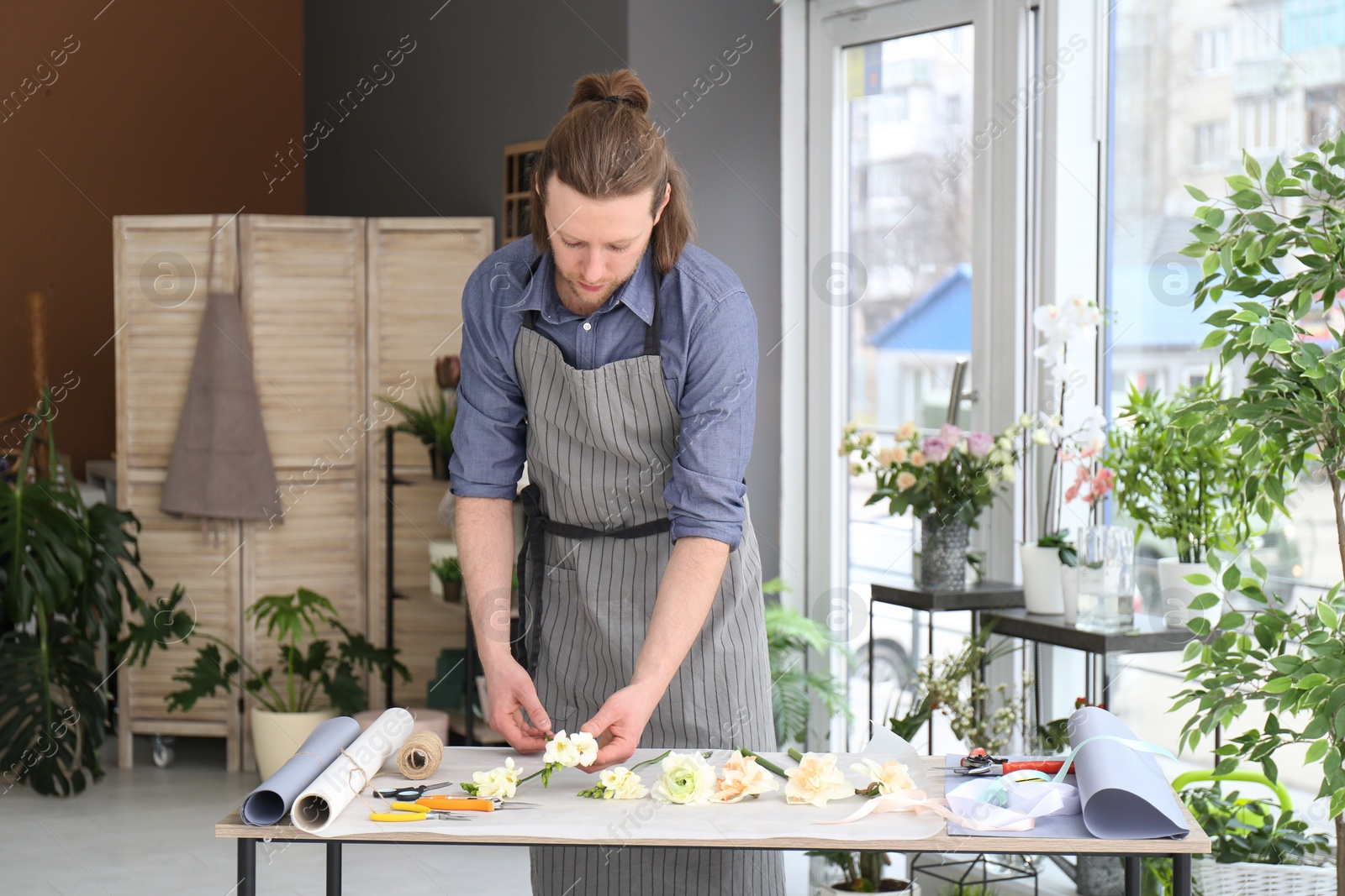 Photo of Male florist creating bouquet at workplace