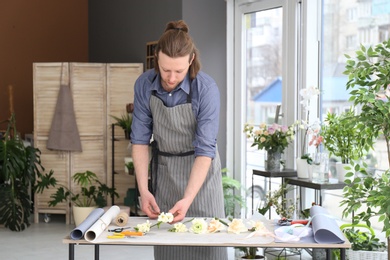 Male florist creating bouquet at workplace