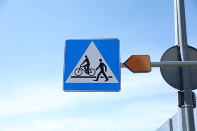 Road sign pedestrian and bicycle crossing against blue sky
