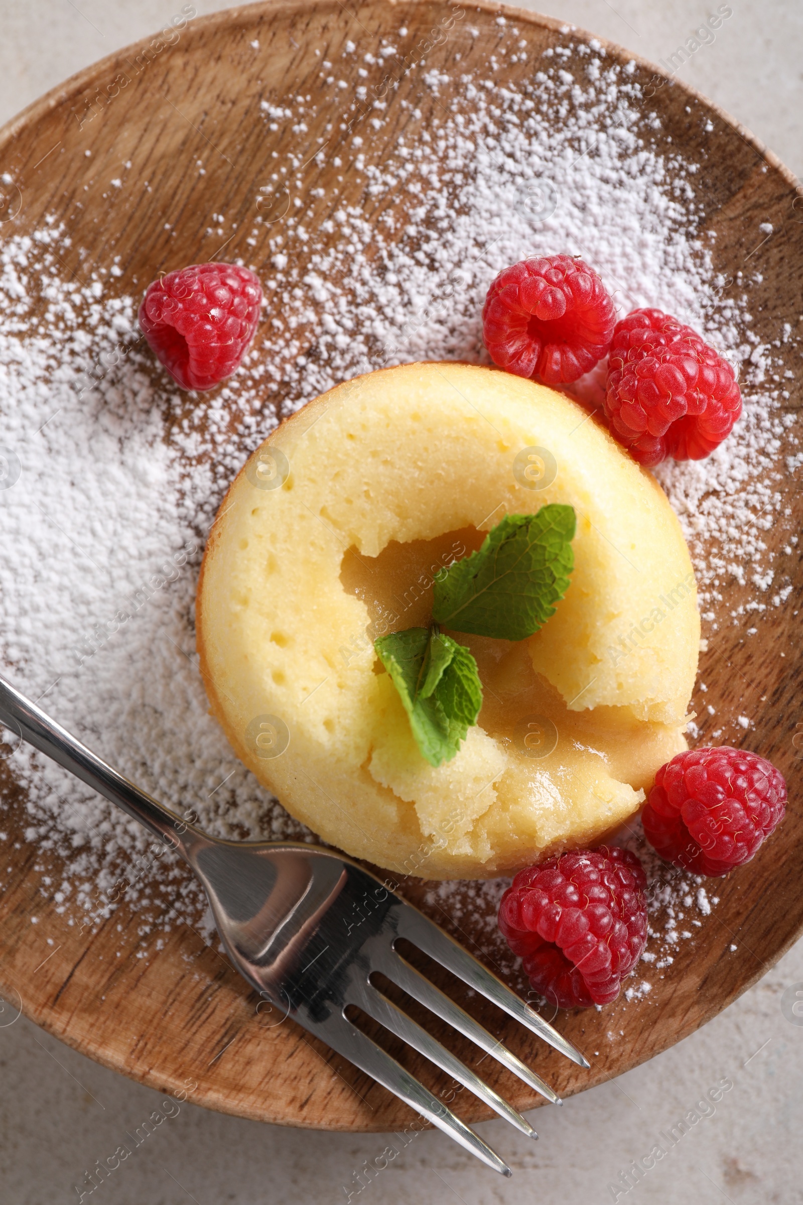 Photo of Tasty vanilla fondant with white chocolate and raspberries on light grey table, top view