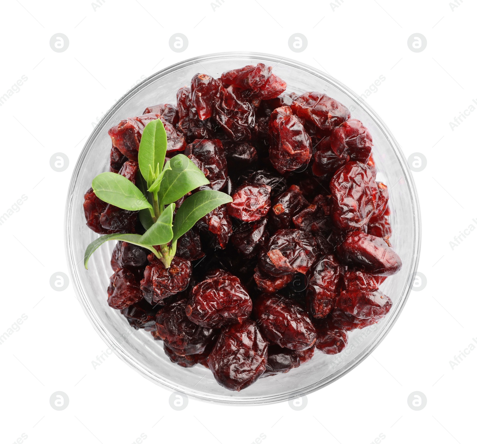 Photo of Tasty dried cranberries and leaves in glass isolated on white, top view