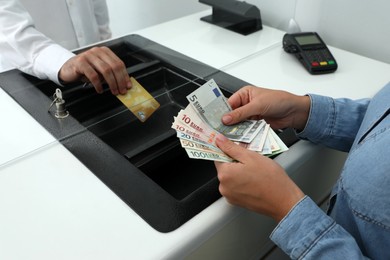 Photo of Woman taking money from card in bank, closeup. Currency exchange