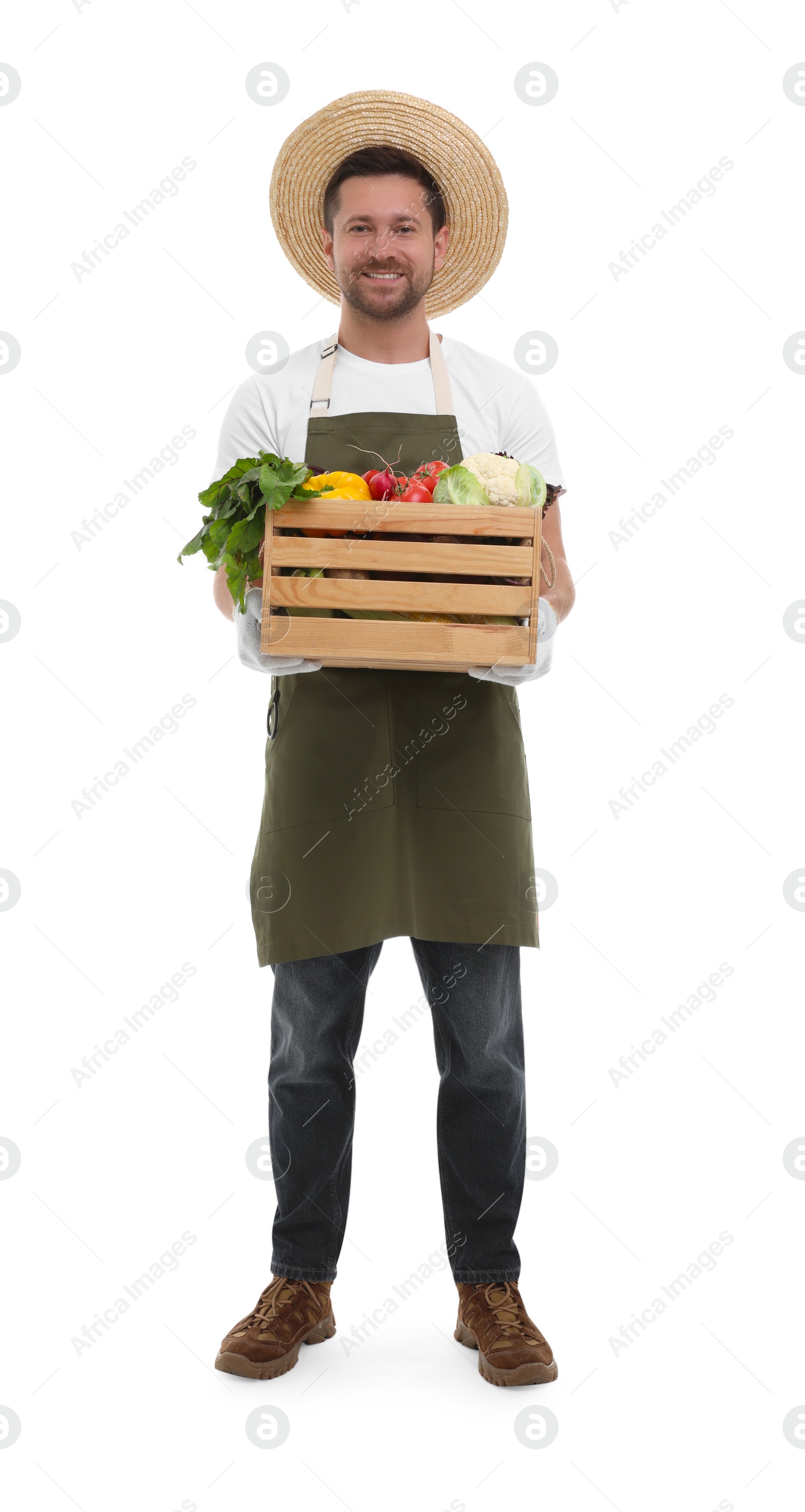 Photo of Harvesting season. Happy farmer holding wooden crate with vegetables on white background