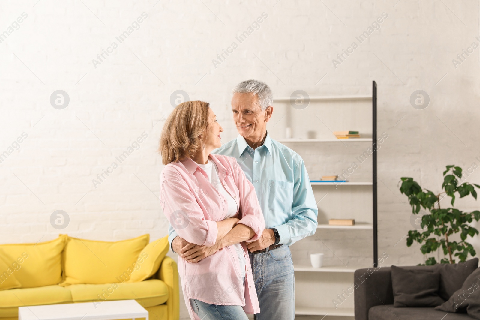 Photo of Happy senior couple dancing together in living room