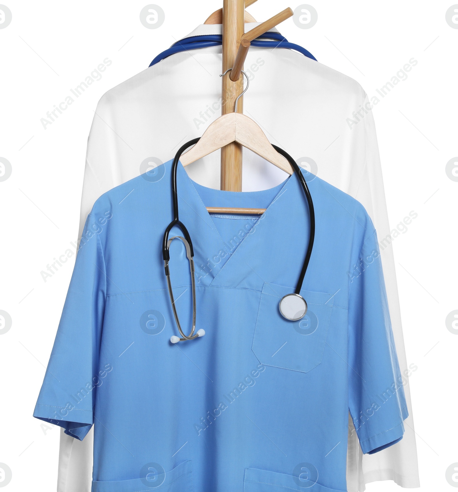 Photo of Light blue medical uniform with stethoscope and doctor's gown on rack against white background