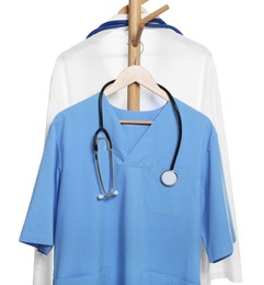 Photo of Light blue medical uniform with stethoscope and doctor's gown on rack against white background