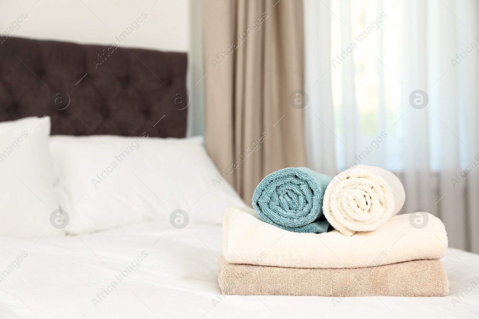 Photo of Soft clean terry towels on bed. Space for text