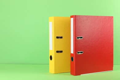 Photo of Office folders on light green background, space for text