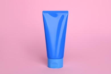 Photo of Tube of face cleansing product on pink background. Space for text