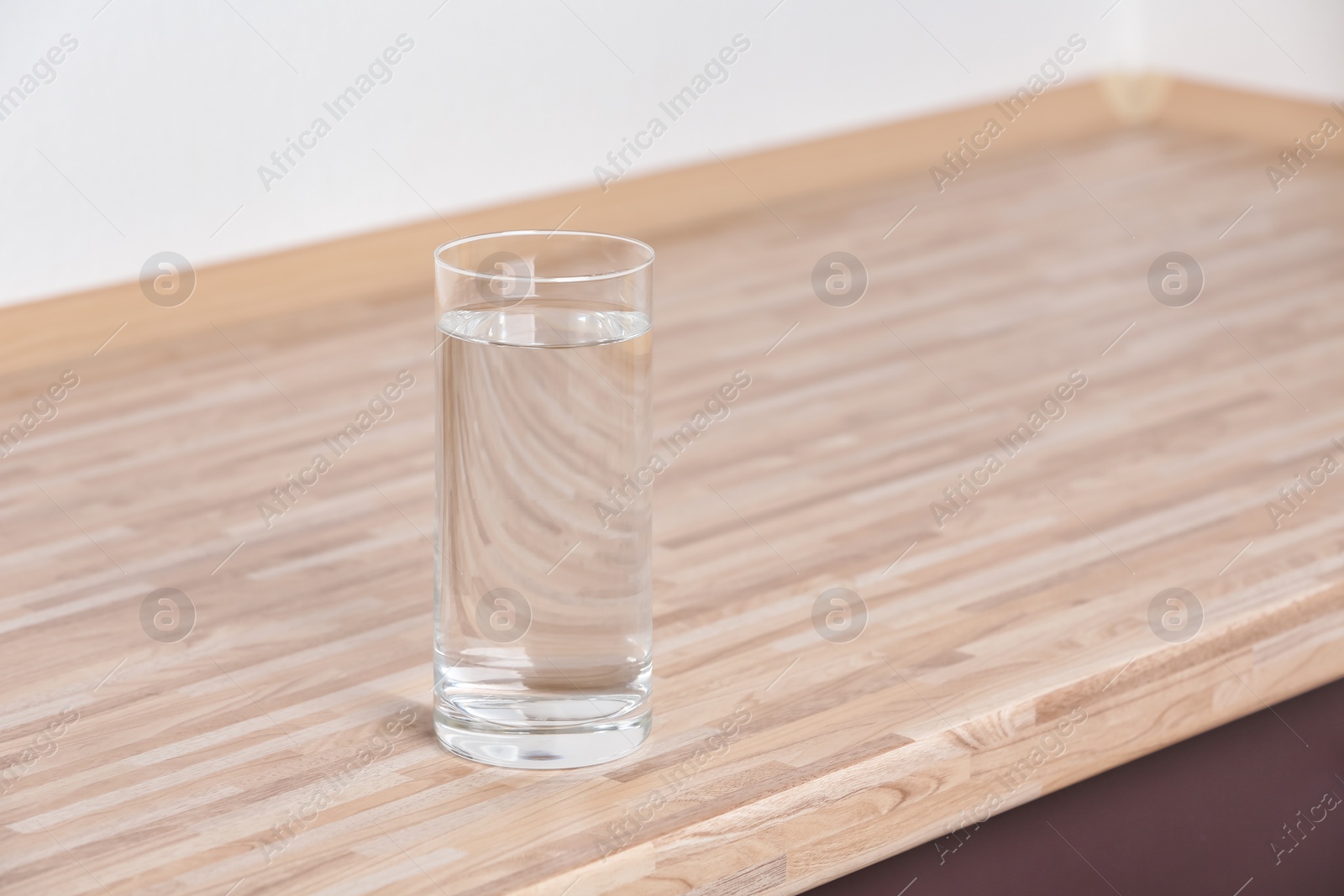 Photo of Glass with fresh water on table in kitchen. Space for text