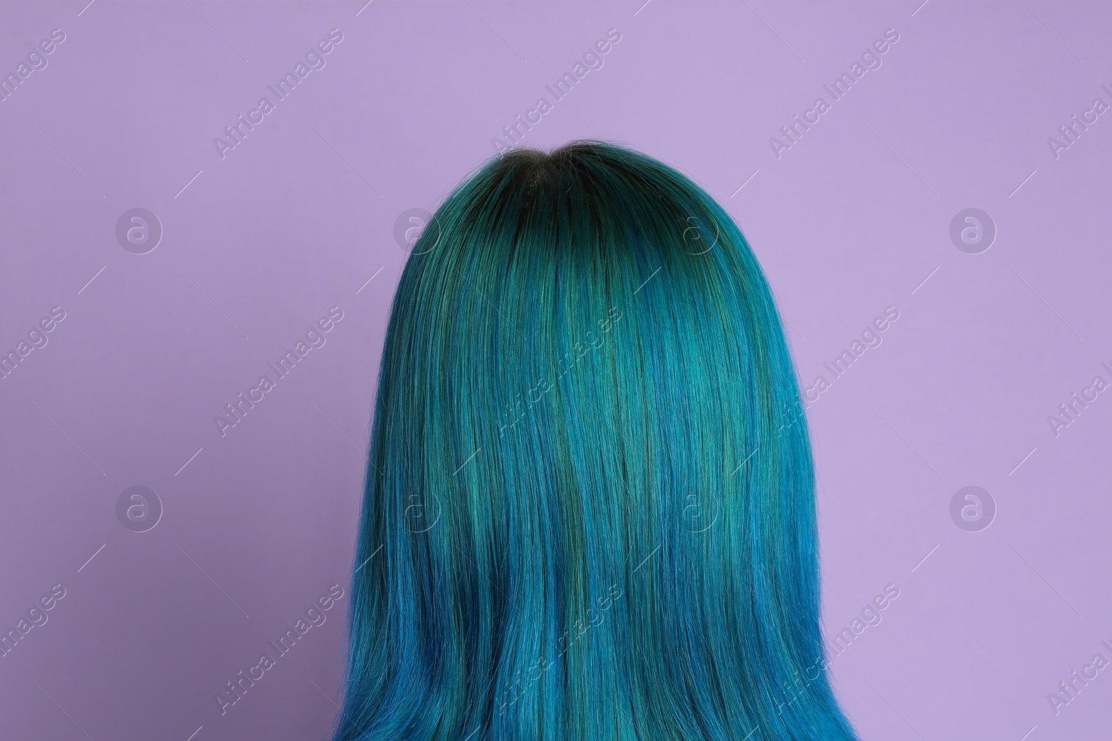 Photo of Woman with bright dyed hair on lilac background, back view