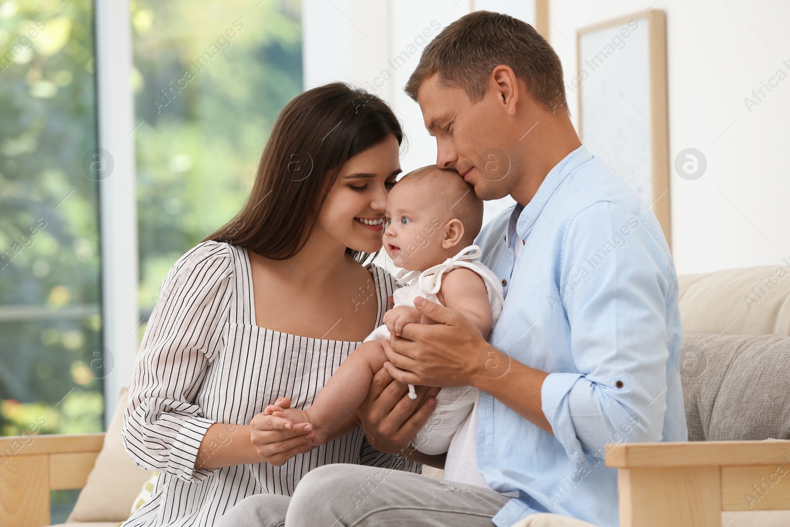 Photo of Portrait of happy family with their cute baby at home