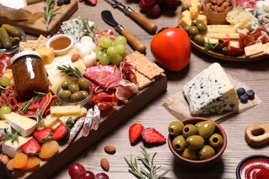 Photo of Many different appetizers served on wooden table