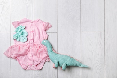 Photo of Stylish baby clothes and toy on wooden background, top view. Space for text