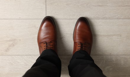 Photo of Businessman in elegant leather shoes on floor, above view