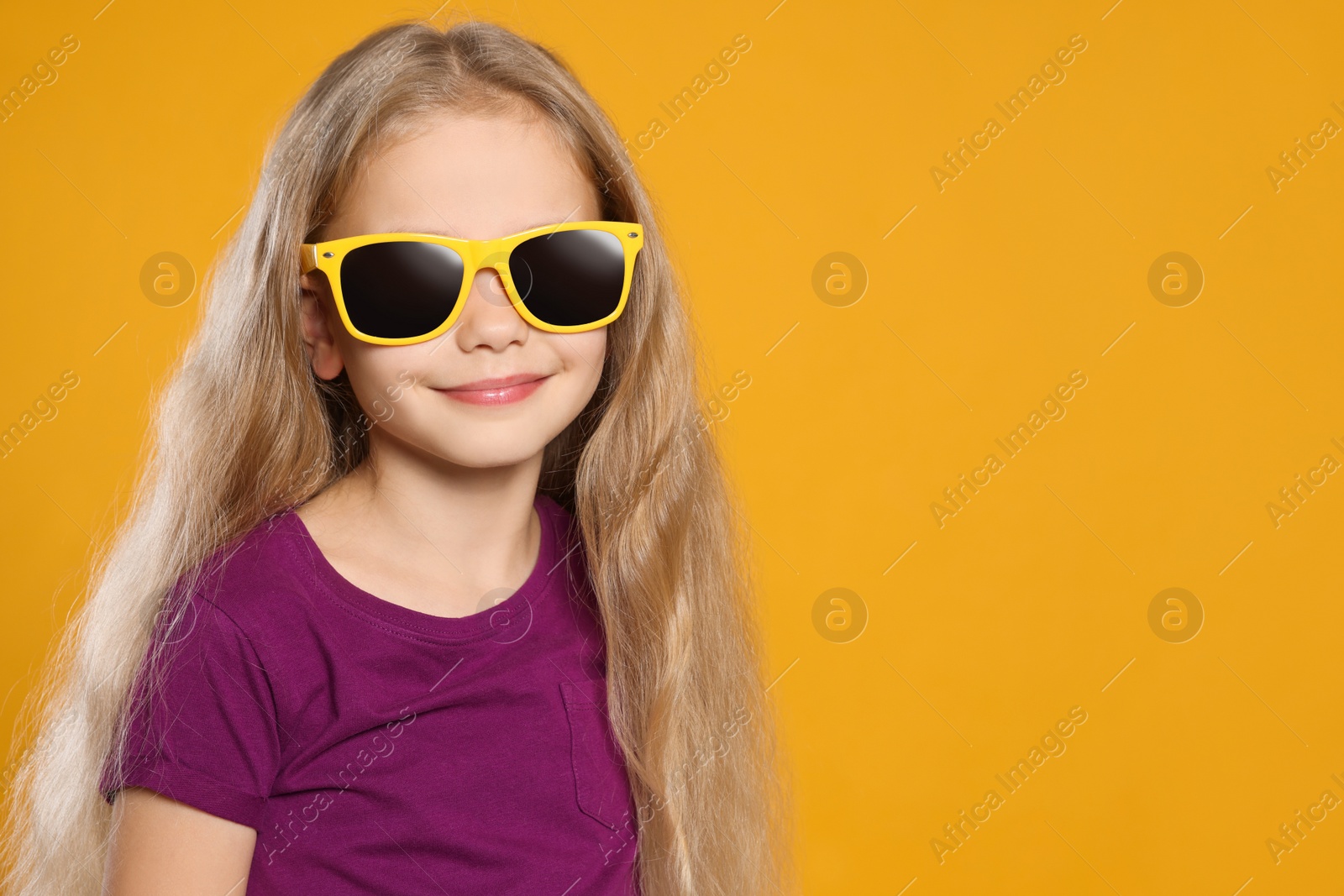 Photo of Girl wearing stylish sunglasses on orange background, space for text