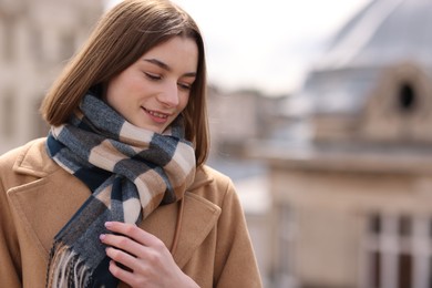 Photo of Beautiful woman in warm scarf outdoors, space for text